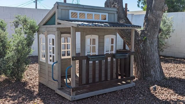 Wooden playhouse for the little ones under a shade tree