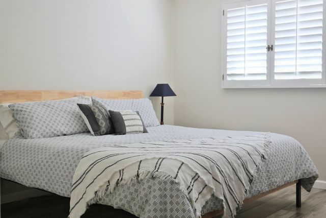 Master suite with king bed and plantation shutters