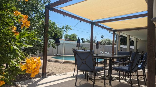 Shaded patio with bougainvillea and a view of the pool