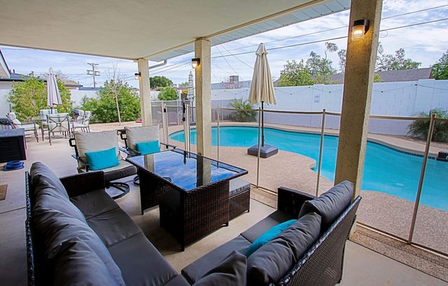 Covered patio lounge seating overlooking the pool