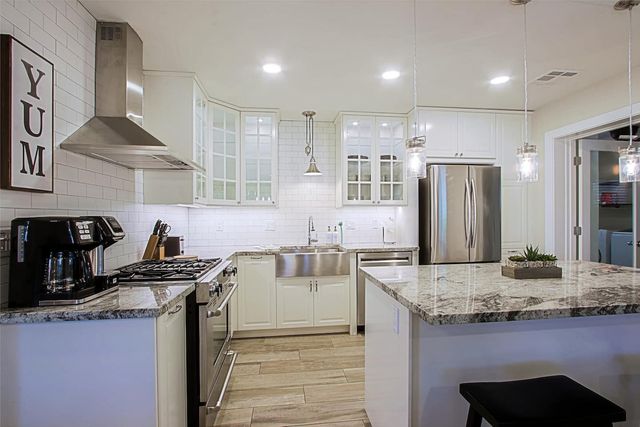 Renovated white kitchen with gas range and stainless appliances