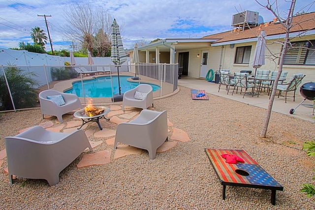 Fire pit seating area and cornhole boards in the backyard